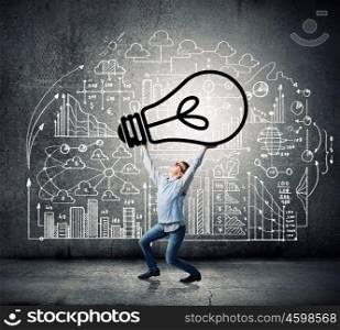 My great idea. Young man lifting light bulb above head