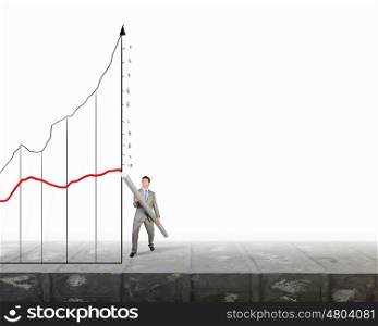 My great plan. Businessman drawing growing graph with huge pencil