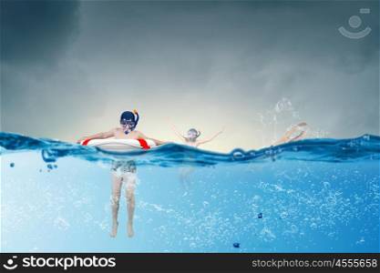 My great summer vacation. Kid boy of school age in diving mask swimming in life buoy