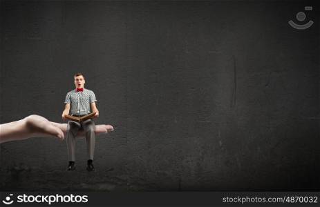 My hobby is reading. Young man student sitting with book in hands