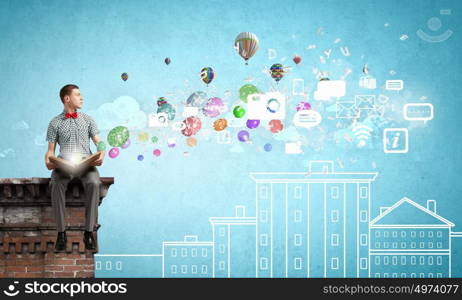 My hobby is reading. Young man student sitting with book in hands