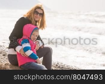 My mother and five year old daughter sit on the beach and looked at turning frame