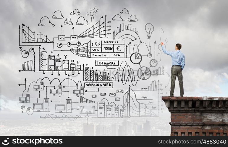 My strategy plan. Back view image of businessman drawing sketches on wall