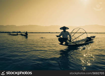 Myanmar travel attraction landmark - Traditional Burmese fisherman at Inle lake, Myanmar famous for their distinctive one legged rowing style