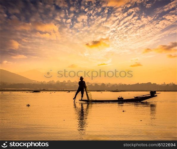 Myanmar travel attraction landmark - traditional Burmese fisherman sihouettes at Inle lake on sunset, Myanmar famous for their distinctive one legged rowing style