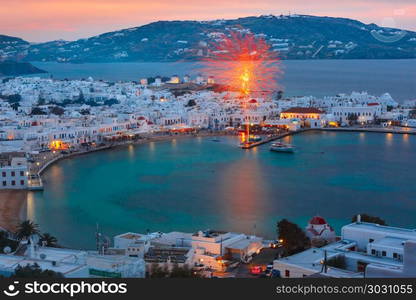 Mykonos City, Chora on island Mykonos, Greece. Aerial view of Mykonos City, Chora with Old Port, white houses, windmilles and churches on the island Mykonos, The island of the winds, during evening blue hour, Greece