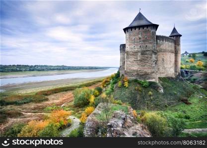 Mysterious castle on river bank under a cloudy sky. Mysterious castle on river bank