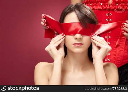 Mysterious girl in red with the covered eyes, isolated