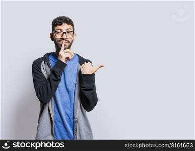 Mysterious person pointing to the side with his fingers on isolated background, Mysterious man pointing to the side with his fingers