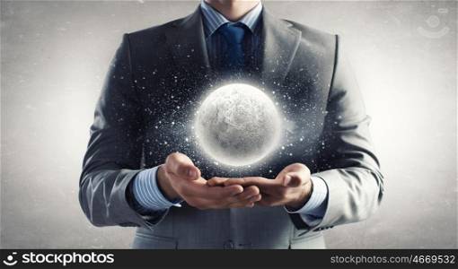 Mystery of moon. Close up of businessman holding moon planet in palms