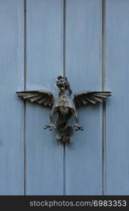 mythological gryphon sculpture on wooden door planks