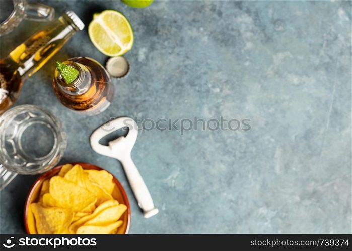 Nachos and beer on blue background, flat lay, copy space