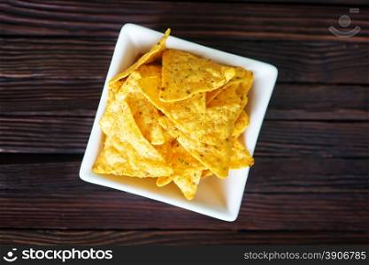 nachos in the white bowl and on a table