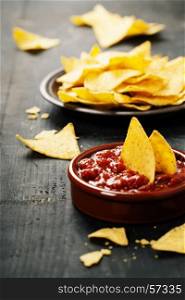 Nachos with Salsa dip on rustic background
