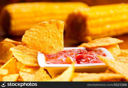 nachos with salsa on wooden table