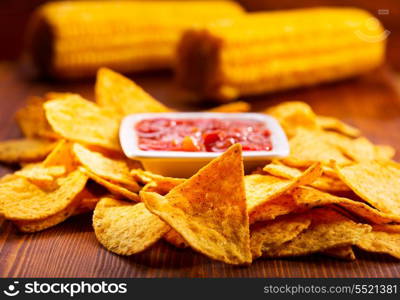 nachos with salsa on wooden table