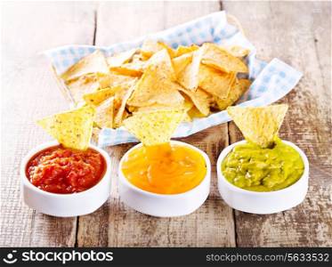 nachos with various sauces on wooden table