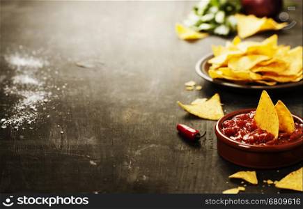 Nachos with Vegetables and dip on rustic background