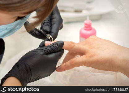 Nail master removing nails cuticle with a nipper, manicure hygiene in a beauty salon. Nail master removing nails cuticle with a nipper, manicure hygiene in a beauty salon.