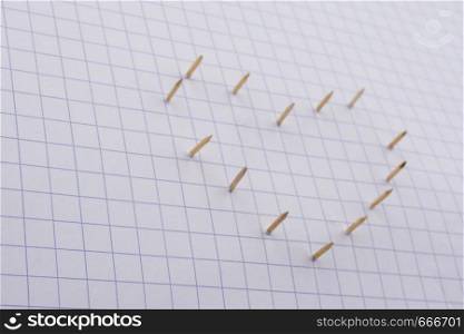 Nails make hole on paper forming a heart shape