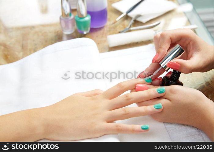 Nails painting with brush in Nail Salon woman hands
