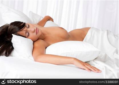 Naked brown hair woman sleeping in white bed, focus on eyes, shallow DOF