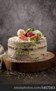 Naked cake with strawberries on kitchen counter top.