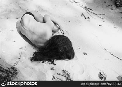 Naked lady lying on beach monochrome scenic photography. Summer. Picture of woman with sandy coast on background. High quality wallpaper. Photo concept for ads, travel blog, magazine, article. Naked lady lying on beach monochrome scenic photography