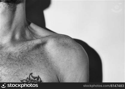 Naked muscular man&rsquo;s shoulder on white background