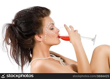 naked sexy woman with hair style and pearl on face drinking from a glass red wine