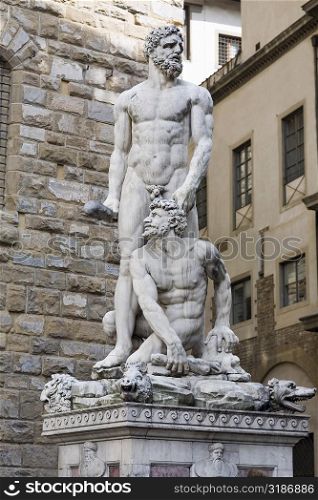Naked statues in front of a brick wall, Hercules and Caco, Piazza della Signoria, Florence, Italy