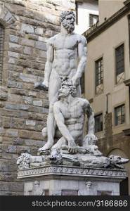 Naked statues in front of a brick wall, Hercules and Caco, Piazza della Signoria, Florence, Italy