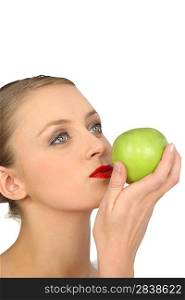Naked woman in full makeup with a green apple