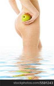 naked woman with green apple standing in water