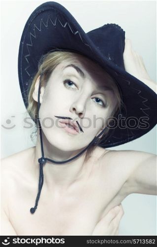Naked women with mustache wearing cowboy hat on light background