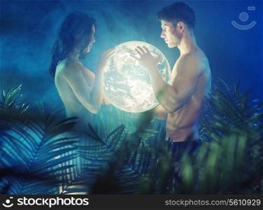Naked young couple holding shiny Earth