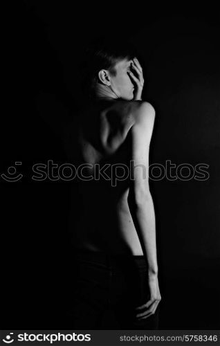 Naked young man on a black background