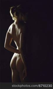 Naked young woman standing