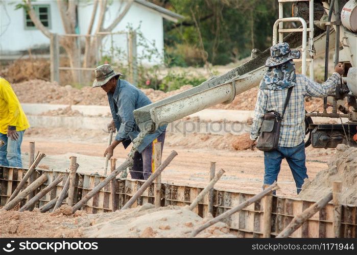 NAKHON PHANOM, THAILAND - DEC 24, 2018 : Concrete mixer truck. Workers are pouring concrete in site building construction