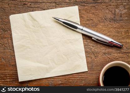 napkin, pen and coffee over grunge wood table, top view