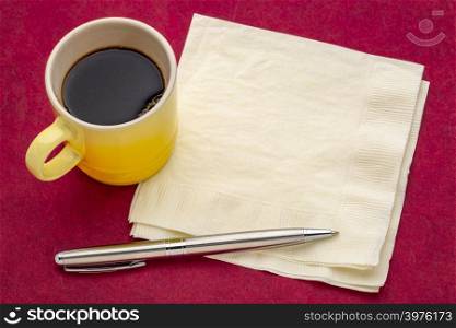 napkin with espresso coffee and pen against red mulkberry paper