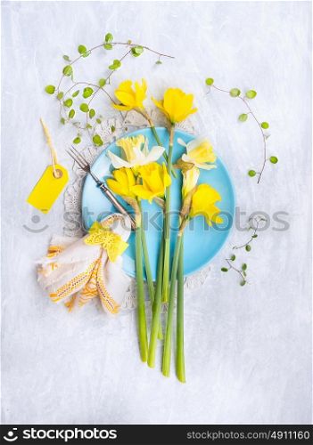 Narcissus bouquet on a blue plate with a yellow napkin , table decoration, top view
