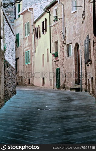 Narrow Alley with Old Buildings in Italian City of Volterra, Vintage Style Toned Picture