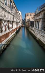 Narrow Canal Among Old Colorful Brick Houses in Venice, Italy