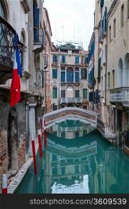 Narrow canal with bridge in Venice, Italy