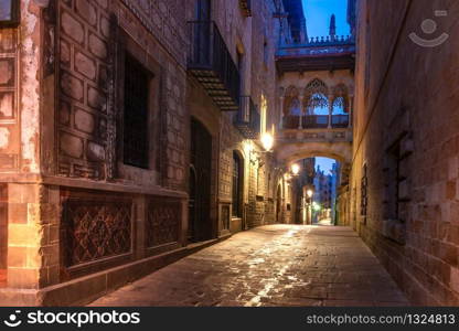 Narrow cobbled medieval Carrer del Bisbe street with Bridge of Sighs in Barri Gothic Quarter in the morning, Barcelona, Catalonia, Spain. Bridge of Sighs in Gothic Quarter, Barcelona