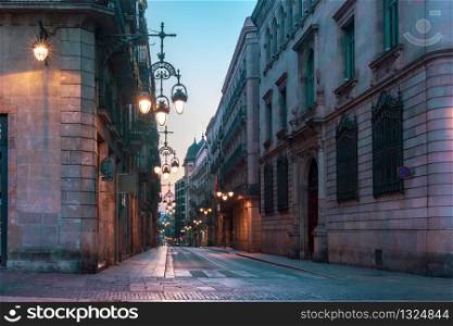 Narrow cobbled medieval empty street with beautiful street lights in Barri Gothic Quarter in the morning, Barcelona, Catalonia, Spain. Empty street in Gothic Quarter, Barcelona