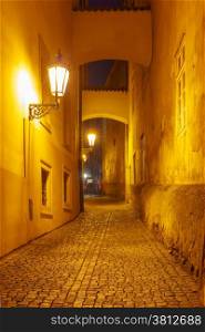 Narrow cobbled street of the old town at night in Mala Strana, Prague, Czech Republic