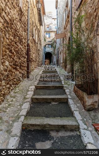 Narrow cobbled street with flowers in the old village Tourrettes-sur-Loup , France.