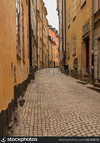 Narrow cobblestone street in Gamla Stan, Stockholm. Narrow street between homes in the old town of Gamla Stan in Stockholm, Sweden. Narrow cobblestone street in Gamla Stan, Stockholm